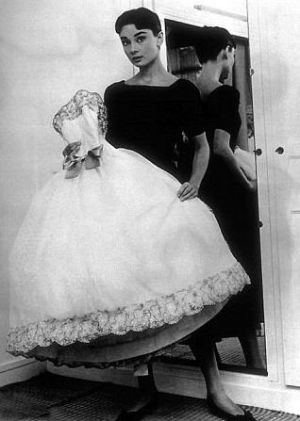 Audrey Hepburn in black frock carrying white frock.JPG
